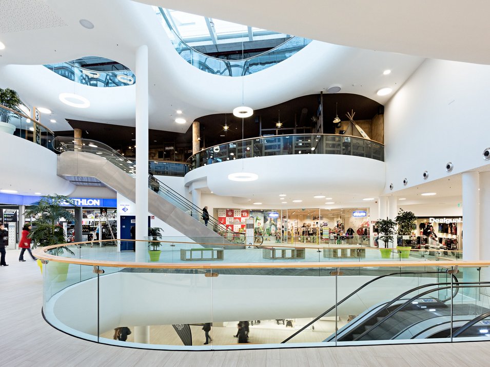 Twenty Shopping Center Bozen – Einkaufszentrum mit internationalen Marken Innenansicht des Twenty Shopping Centers in Bozen mit mehreren Etagen, Rolltreppen, Geschäften und modernem Einkaufsambiente.